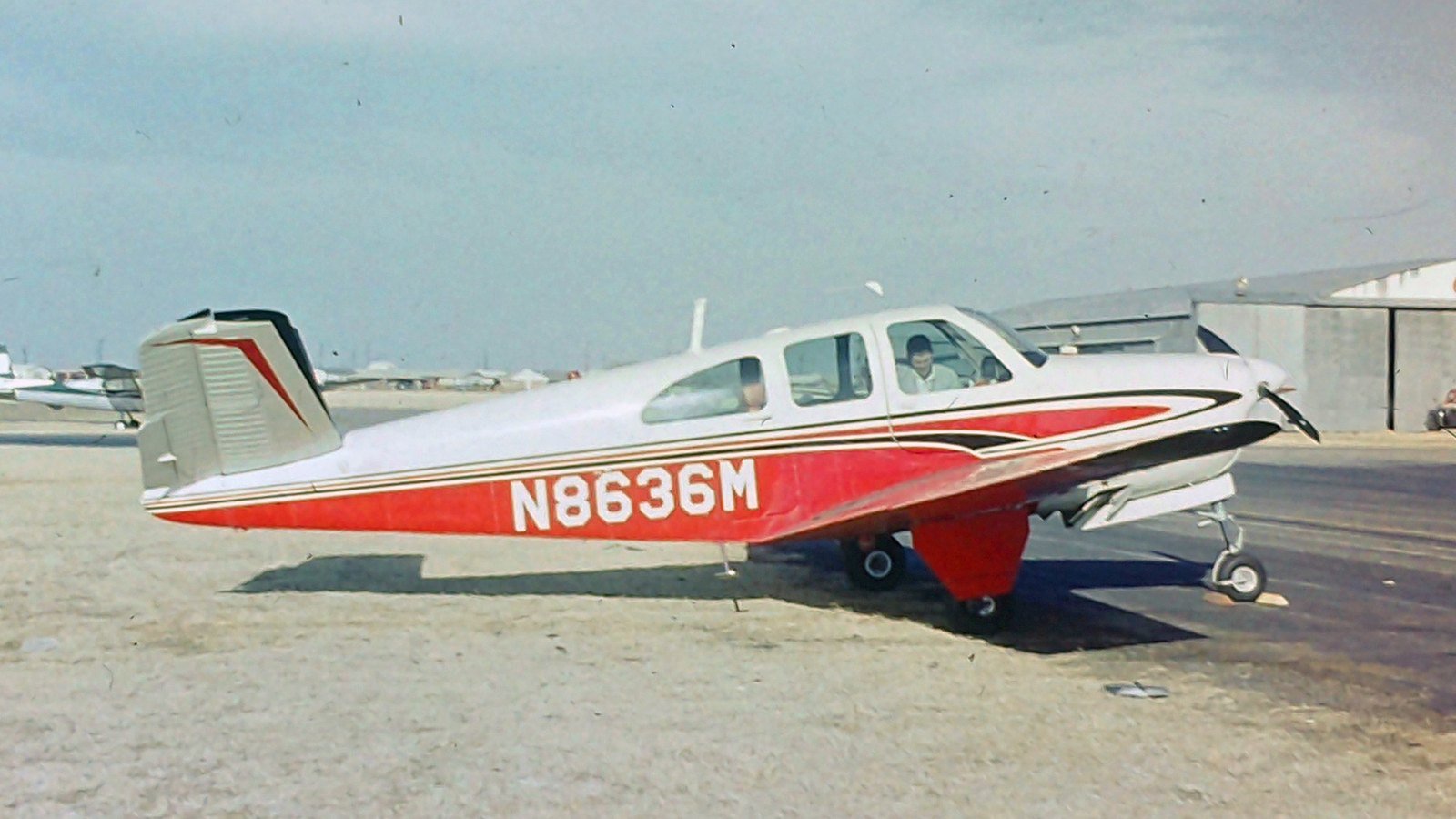 Beechcraft Bonanza P35 N8636M in its original red and white paint, parked on the ramp in 1963